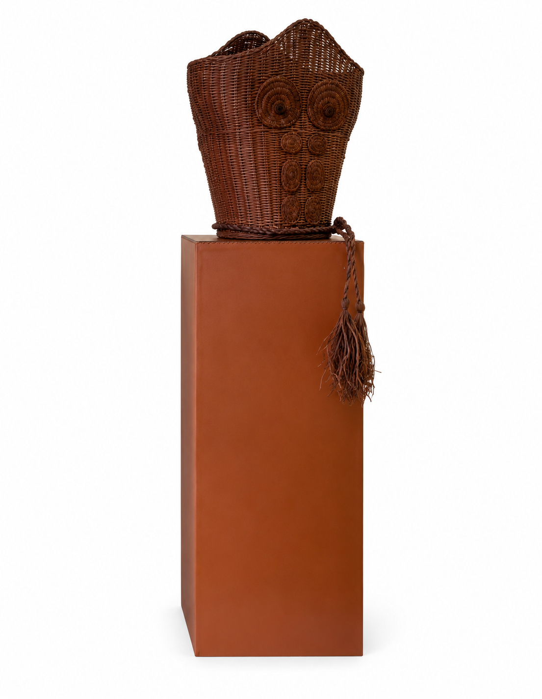 Buste de rotin tressé de Louis Barthélemy, teinte brun foncé, rosaces assorties cousues sur le torse et pompon, posé sur un socle gainé de cuir cognac